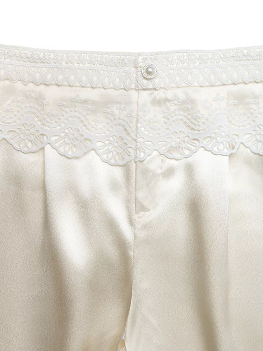 Lace-trimmed high-waist wide-leg pants in beige satin with a pearl button closure.