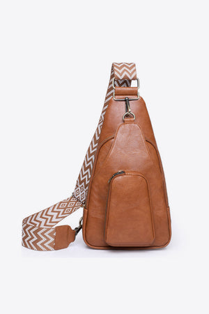 Honey PU sling bag with patterned strap and front zip pocket.