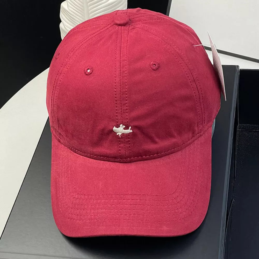 Wine red cotton baseball cap with embroidered detail and ventilation eyelets.