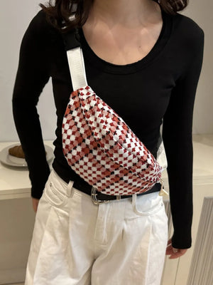 Textured houndstooth belt bag in red and white with adjustable strap.