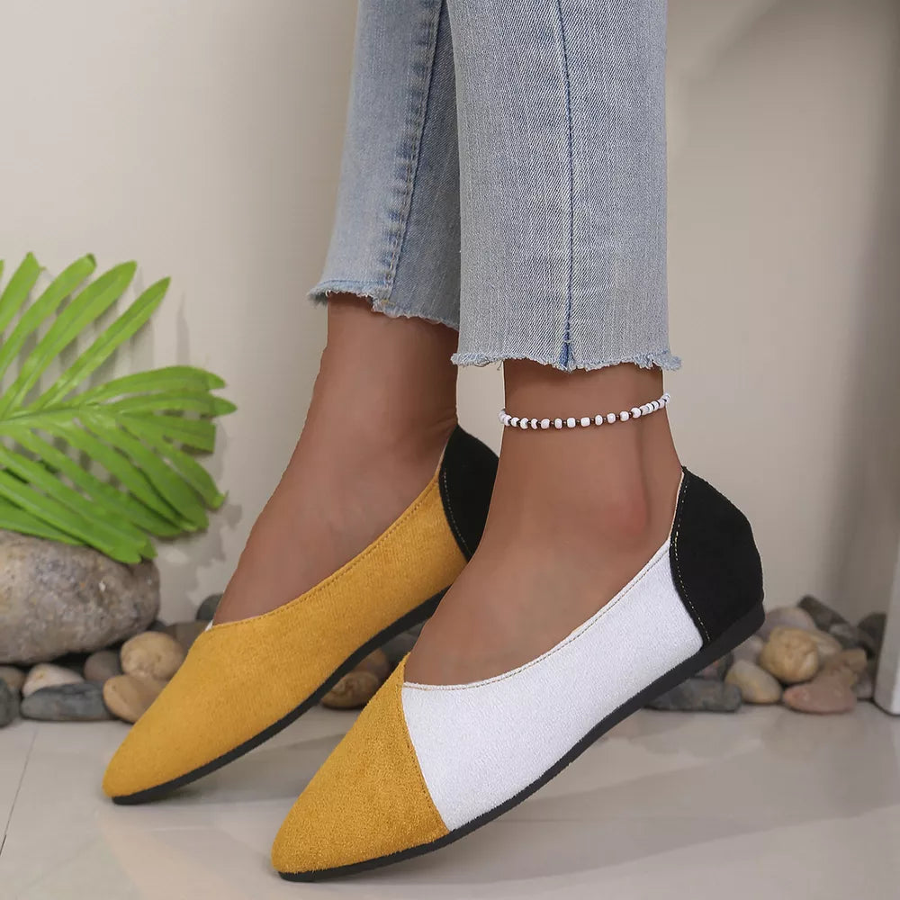 Chic color block pointed-toe slip-on flats in yellow, white, and black.