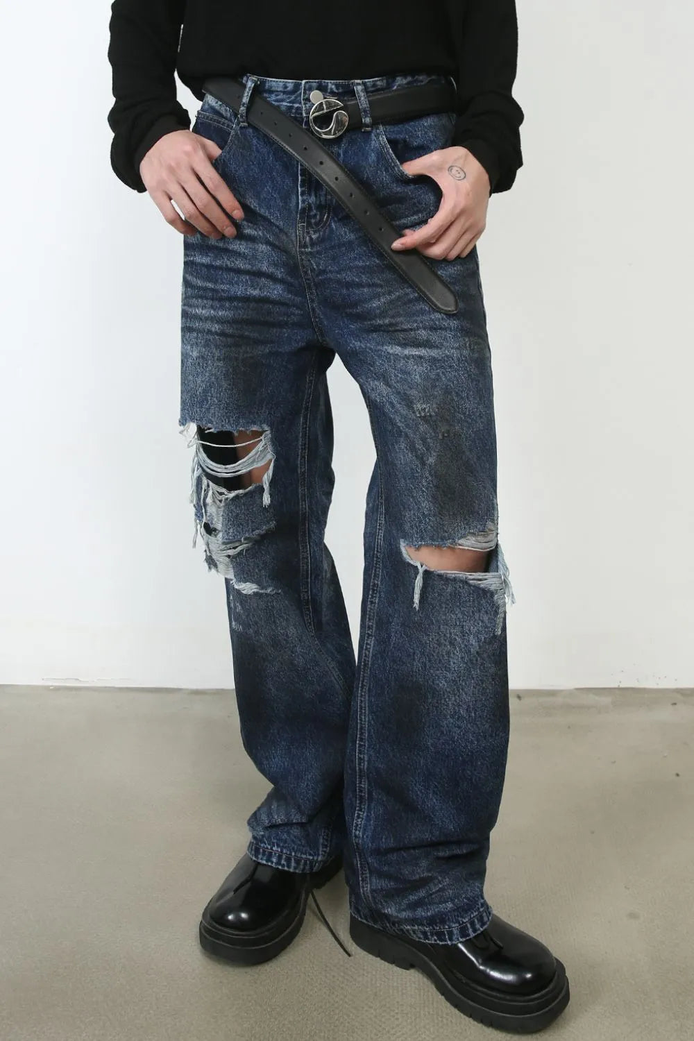 Dark wash distressed cotton jeans with ripped knees and a relaxed fit.