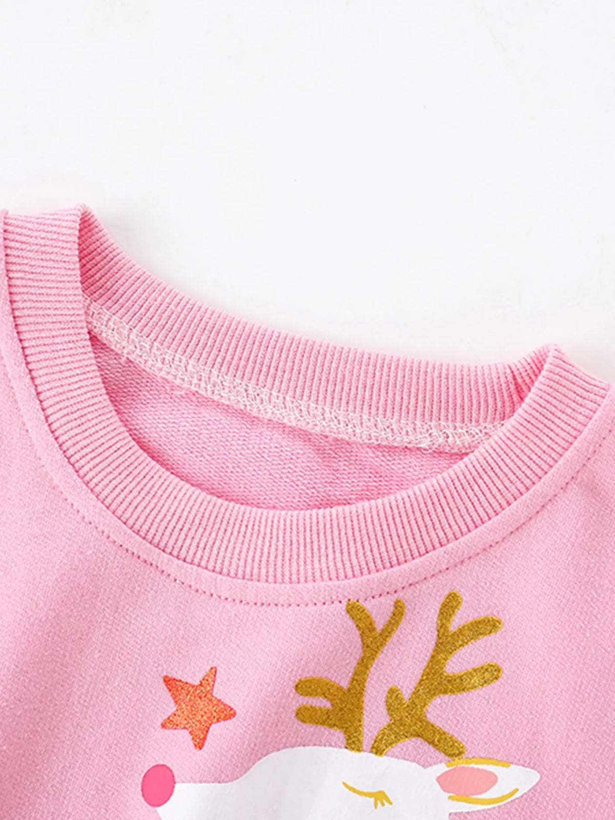Pink crew neck sweatshirt with reindeer graphic and star detail.