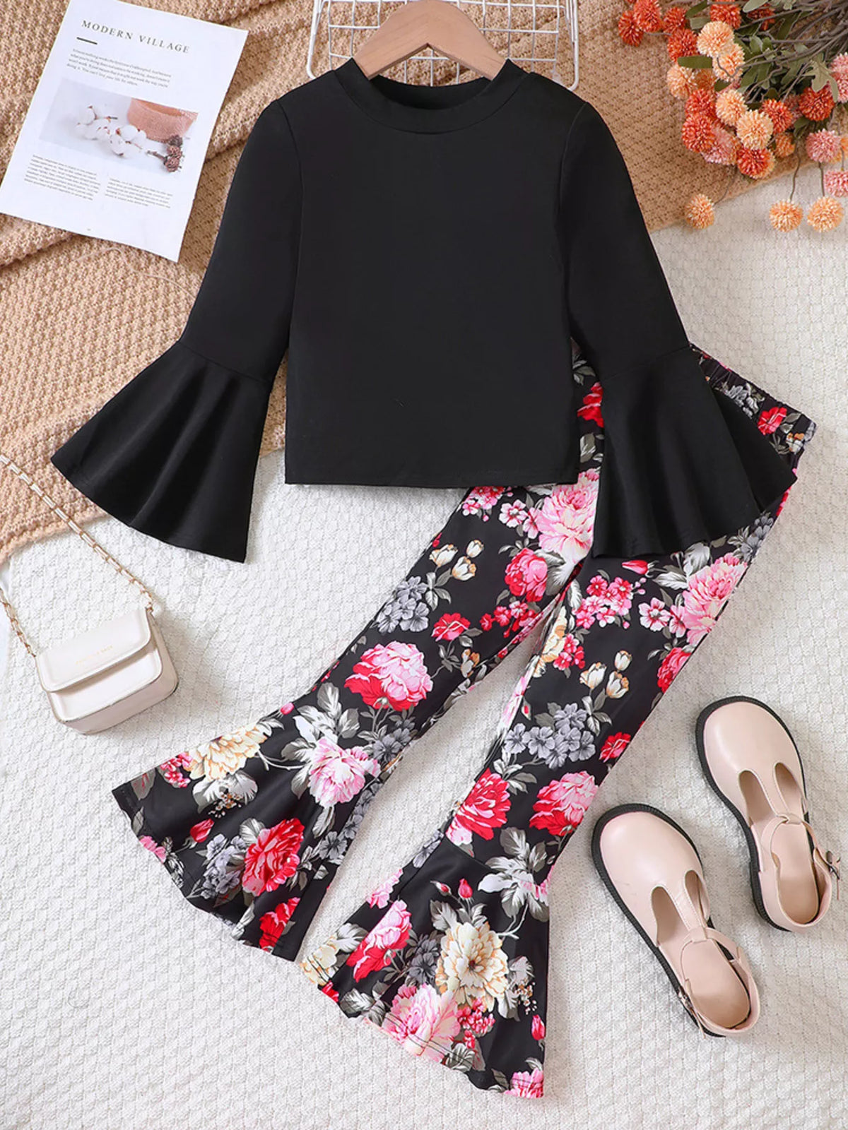 Black flared sleeve top with floral bell bottom pants for baby girls.