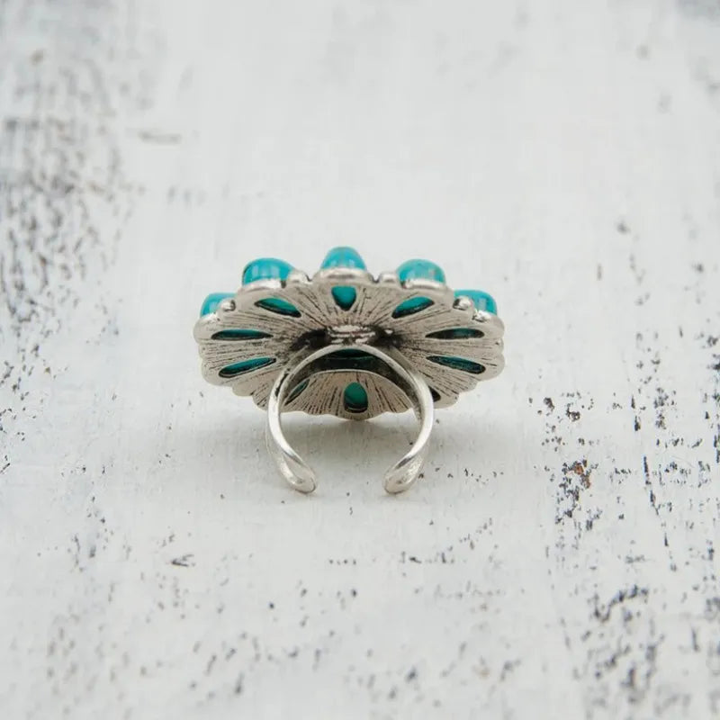 Turquoise blossom statement ring with alloy band and artificial turquoise stones.