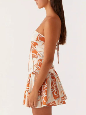 Ruffled tube dress with floral print and back tie detail in cream and orange.