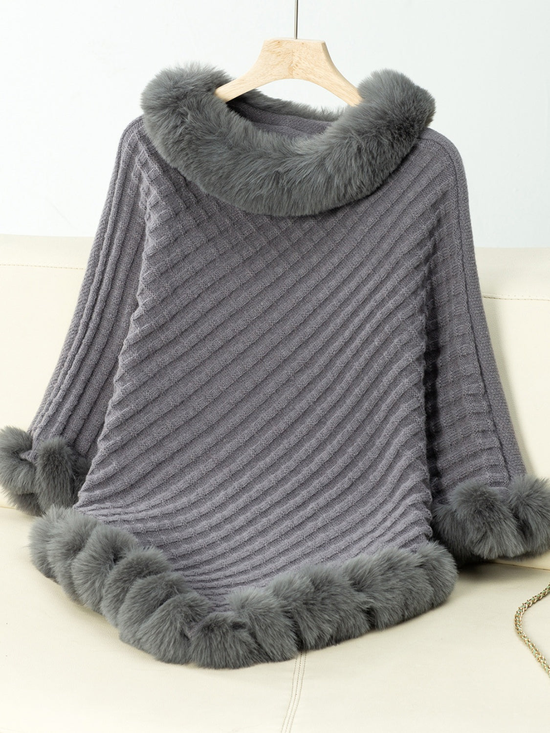 Dark gray knit poncho with faux fur trim on collar, cuffs, and hem