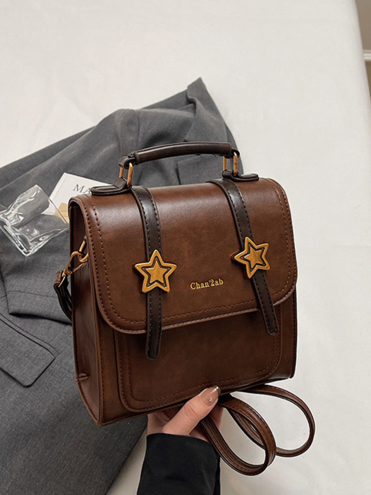 backpack in brown featuring top handle and boxy fit