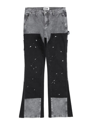 Split panel bootcut jeans in dark gray and black with paint splatter detail.