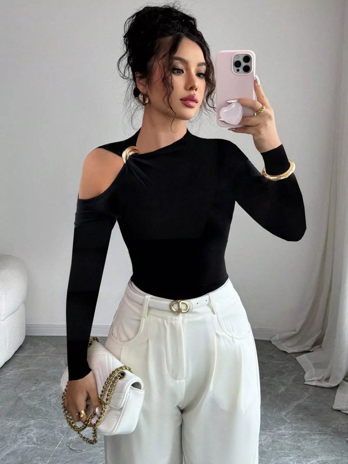 Black one-shoulder t-shirt with cutout and gold ring detail, long sleeves.