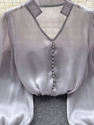 Gray sheer button-down shirt with pearl buttons and V-neckline