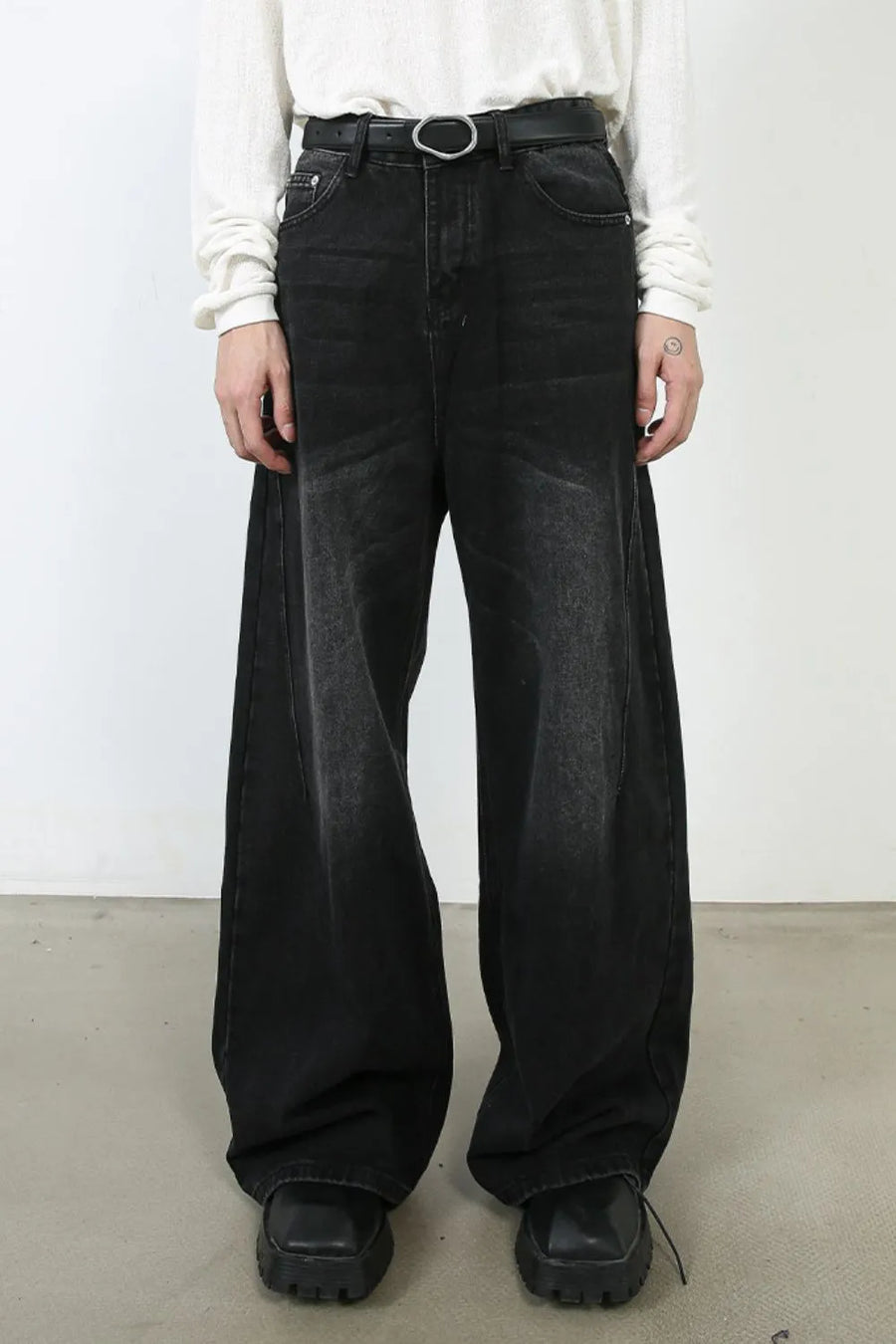 Oversized black wash denim jeans with a wide leg and faded details.
