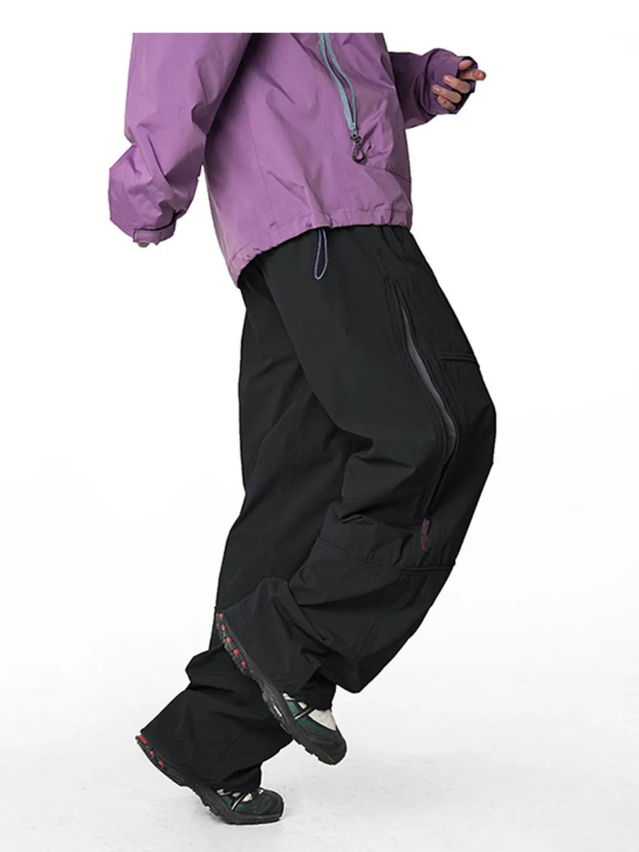 Relaxed fit black cargo pants with drawstring and zippered pockets, shown with a purple jacket.