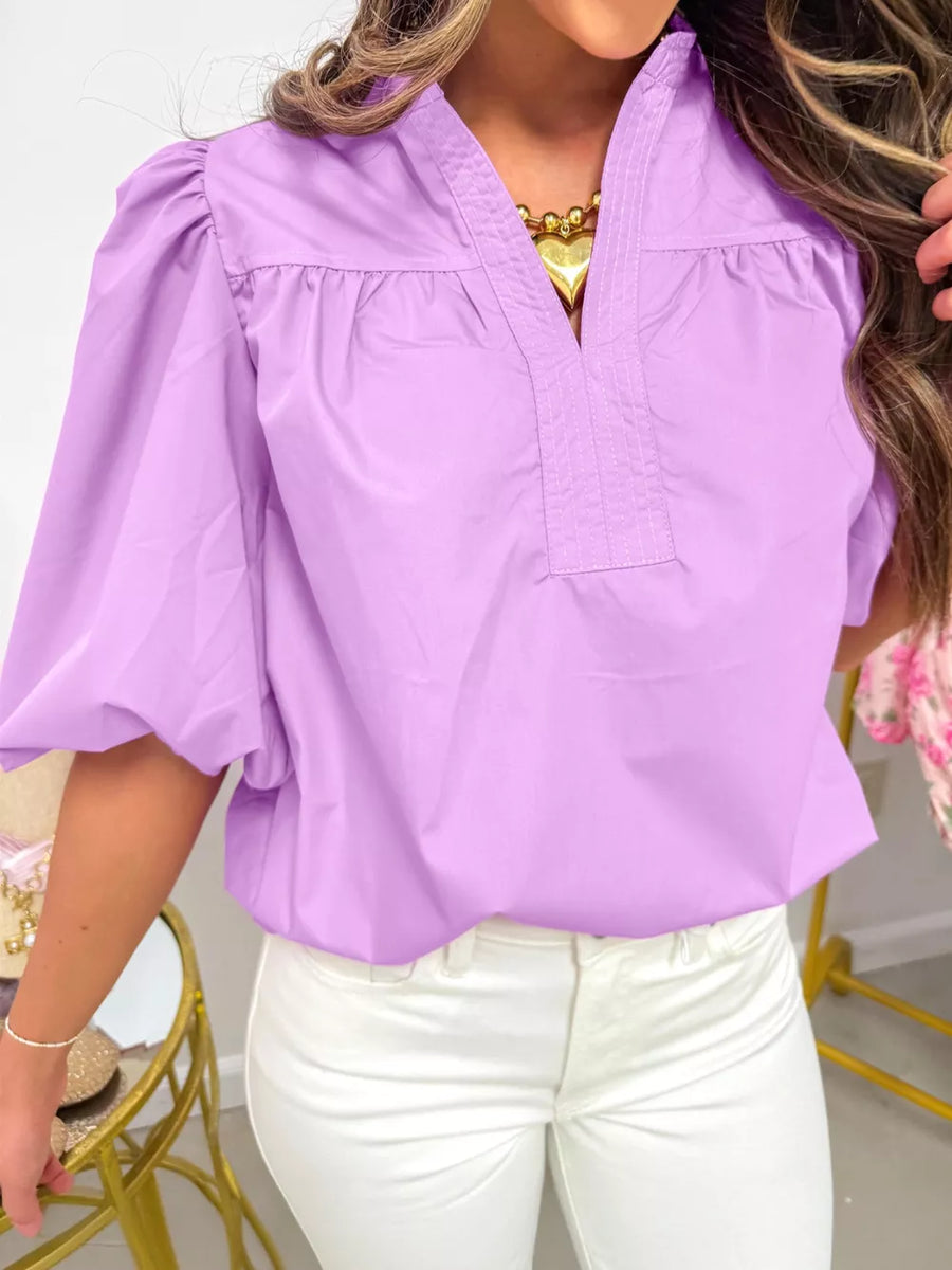 Lilac cotton shirt with notched V-neck, gathered yoke, and puff sleeves.
