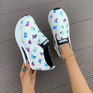 White butterfly print round-toe slip-on flats with air cushion sole and chunky sole detail.