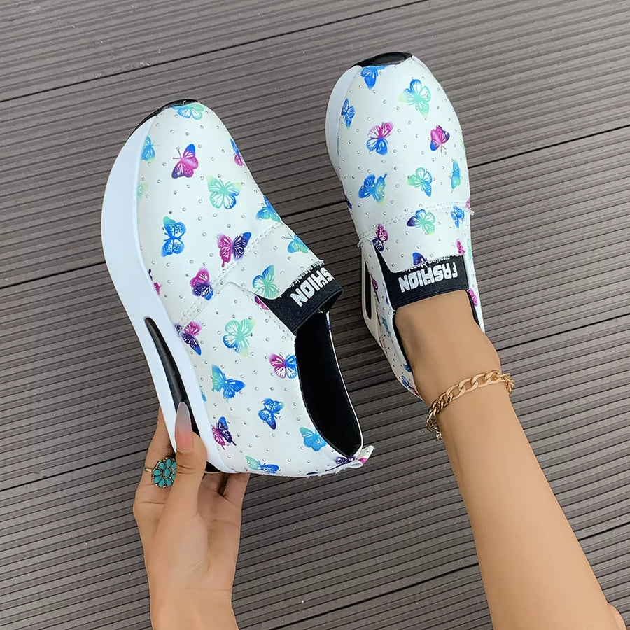 White butterfly print round-toe slip-on flats with air cushion sole and chunky sole detail.