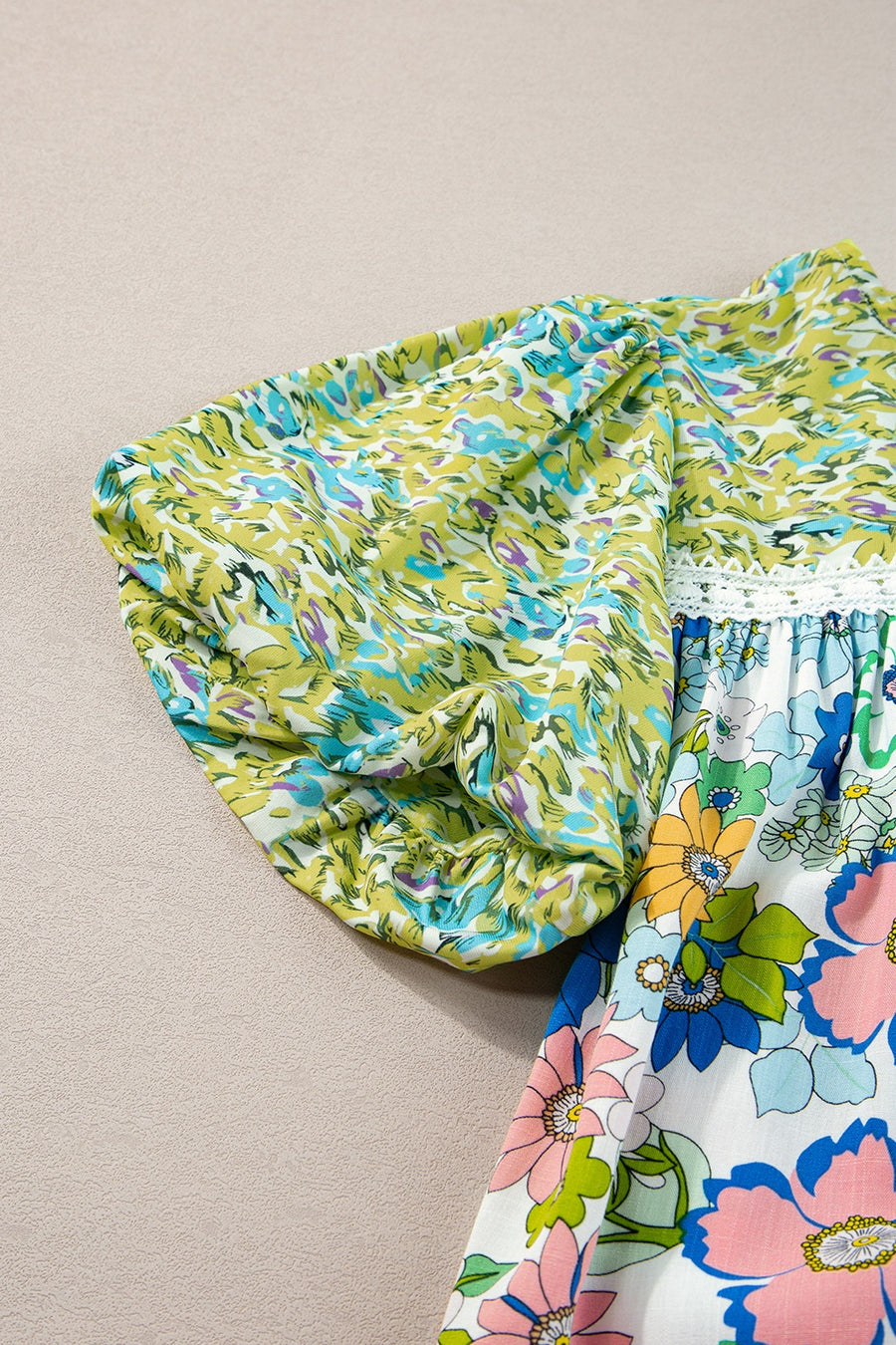 Floral patchwork blouse with puff sleeves and crochet trim, featuring lime and multi-color floral prints.