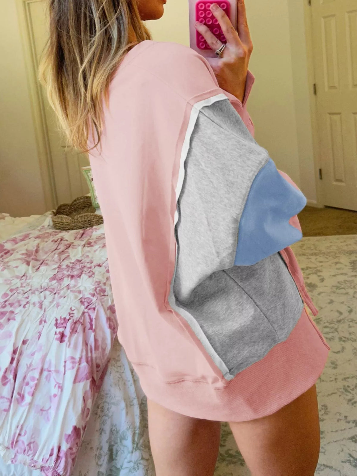 Oversized dusty pink sweatshirt with contrast stitching and colorblock sleeves in gray and blue.