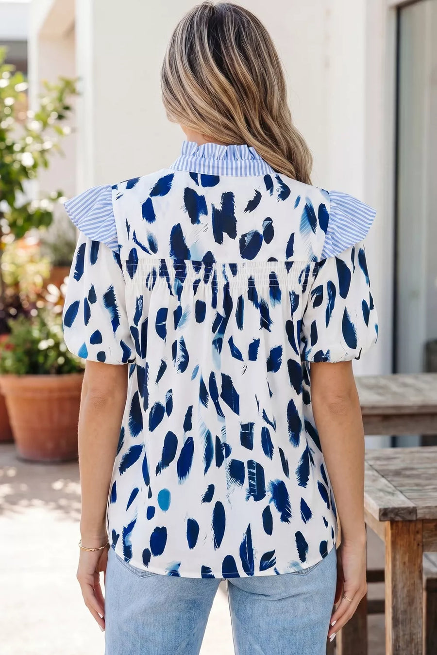 White polyester shirt with blue abstract print, ruffled collar and sleeves.