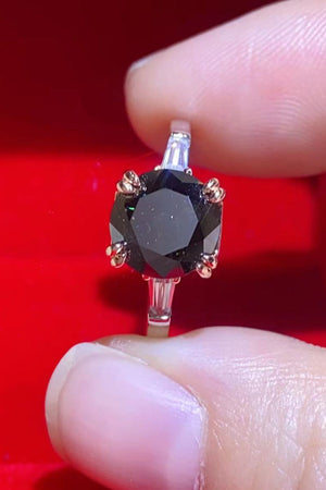 Black moissanite solitaire ring with baguette accents on a sterling silver band.