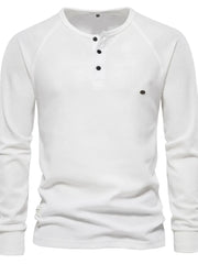 White waffle knit henley shirt with raglan sleeves and black buttons.
