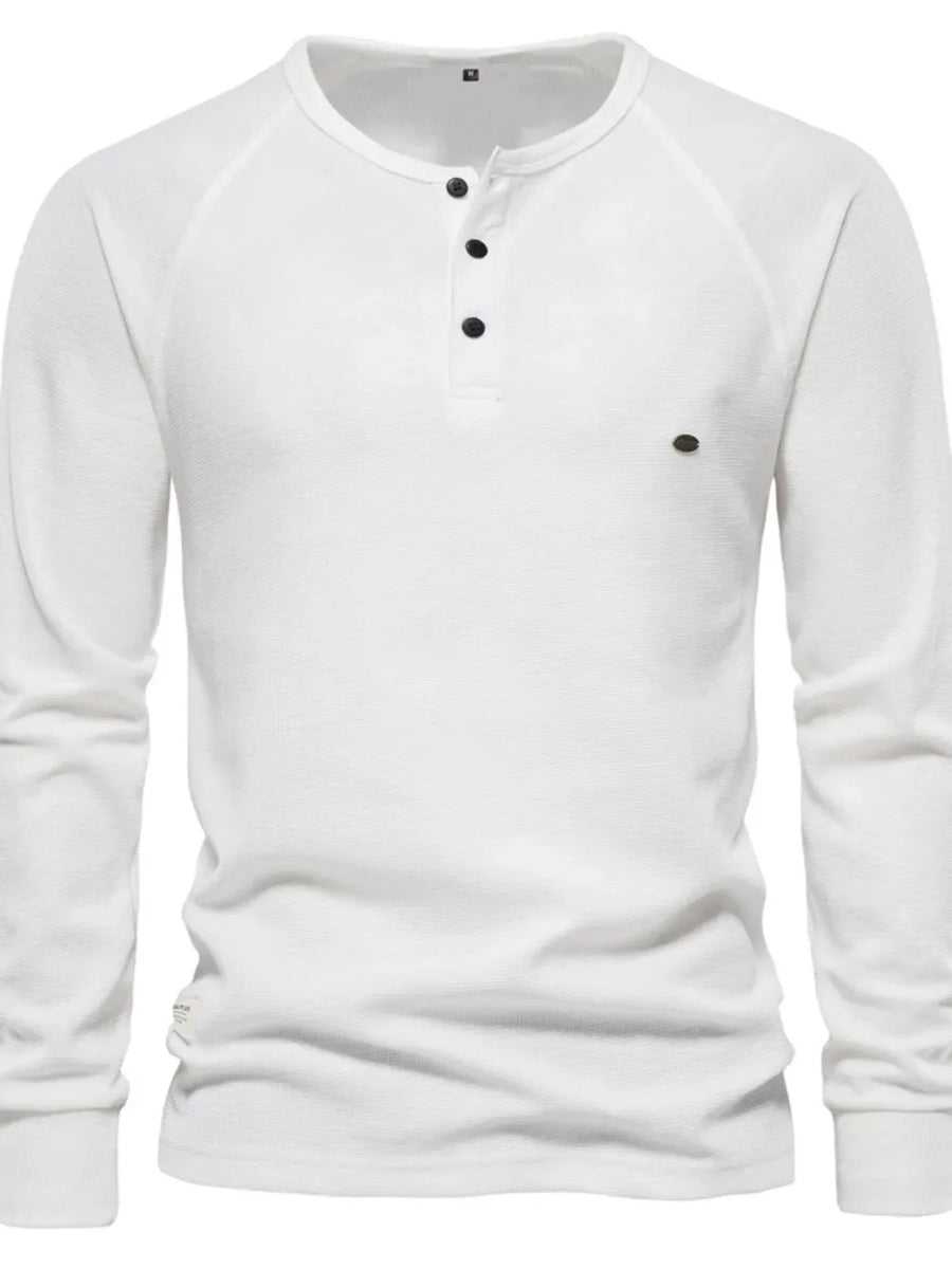 White waffle knit henley shirt with raglan sleeves and black buttons.