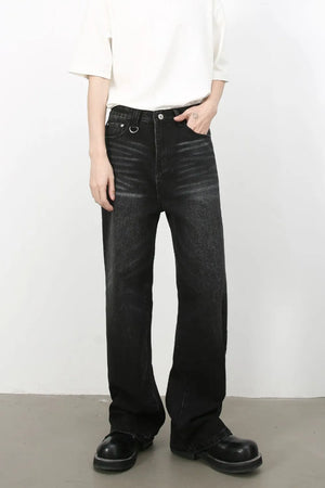 Wide leg distressed black wash denim jeans with a ring detail and cat's whisker effect.