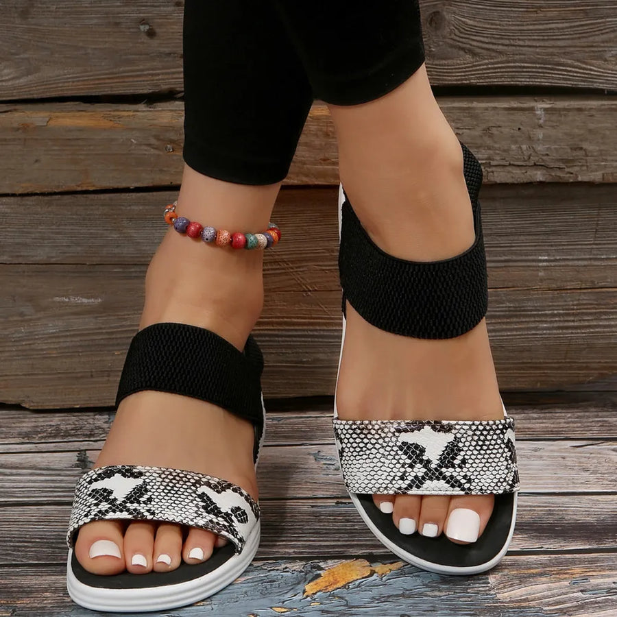 Geometric print elastic strap sandals with black elastic straps and white soles.