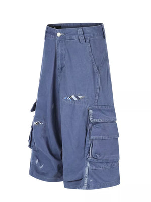 Blue faded cargo capris with distressed detailing and plaid accents.
