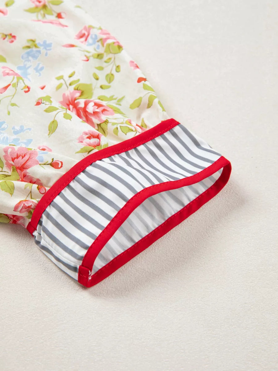 Floral cotton dress with puff sleeves, red trim, and striped cuff detail.