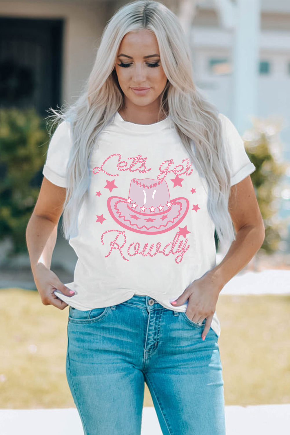 White graphic t-shirt with pink cowboy hat and stars saying Lets Get Rowdy.