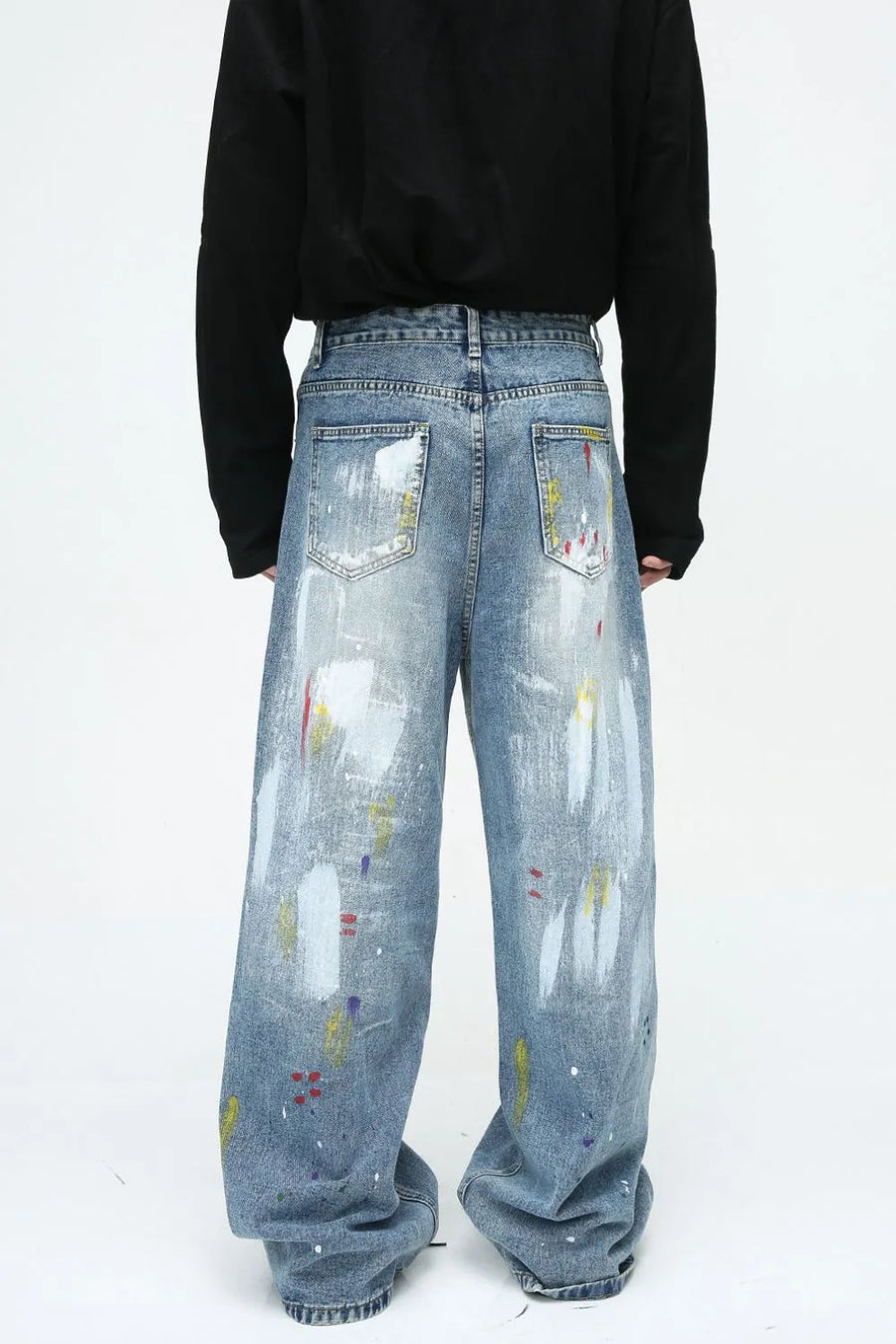 Painterly wash wide-leg denim trousers in medium blue with artistic paint splatters and brushstrokes.