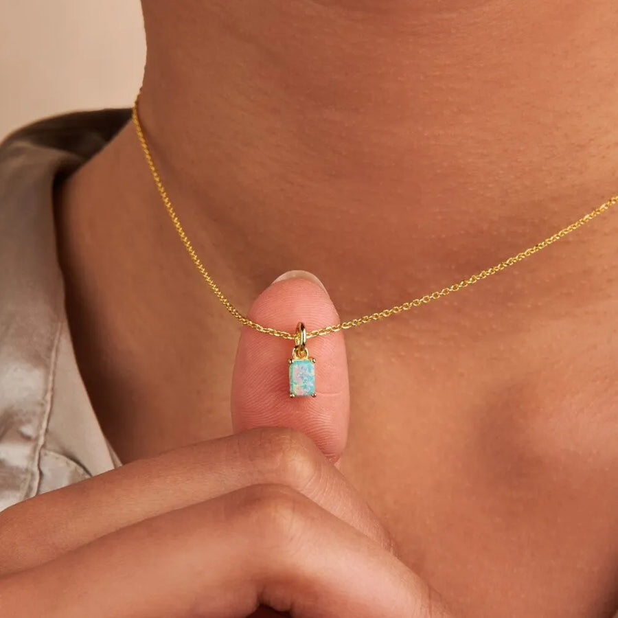 Prism cut gemstone necklace on a delicate 18K gold chain, featuring a small rectangular light blue opal pendant.
