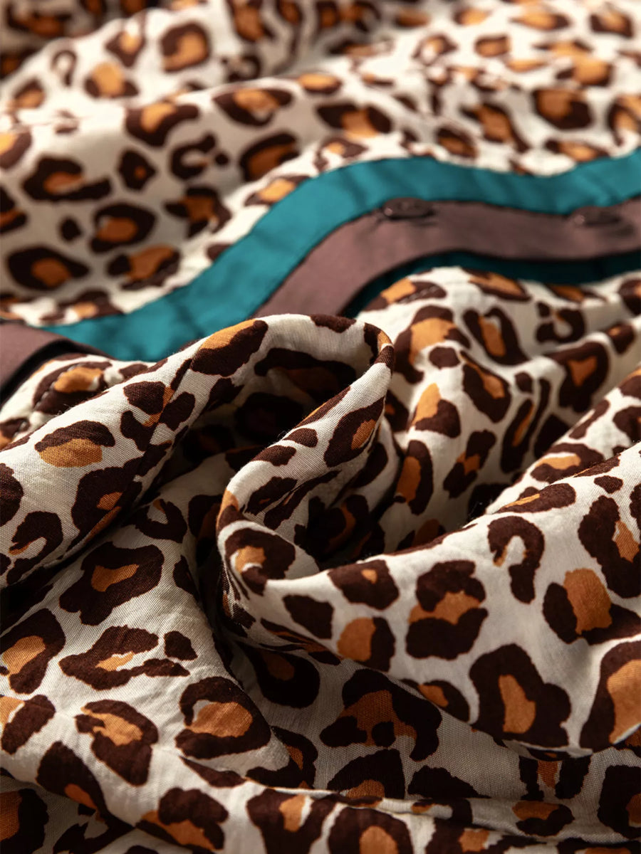 Leopard print button-down shirt with frilled trim detail and contrasting ribbon accents.
