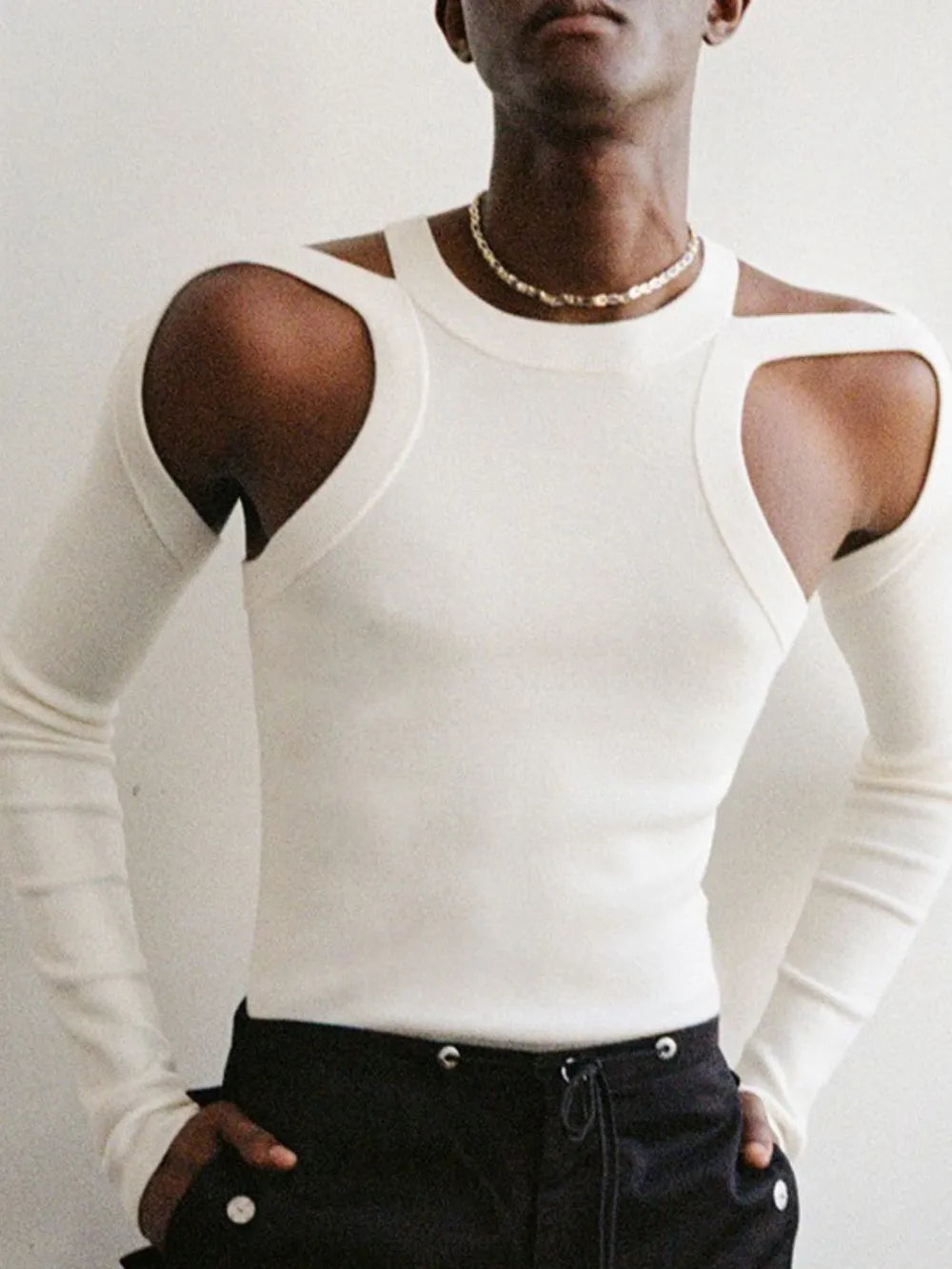 White ribbed knit sweater with shoulder cutouts and long sleeves.