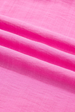 Ruffled sleeveless maxi dress in bright pink textured fabric with smocked waist detail.