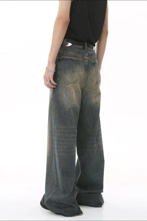 Faded wash palazzo denim trousers in a medium blue with a wide leg and distressed details.