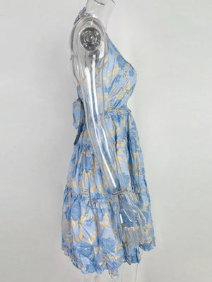 Pastel blue halter mini dress with abstract floral print and tiered ruffles.