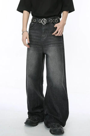 Oversized dark wash denim palazzo trousers with a wide leg and a distressed ombre effect.