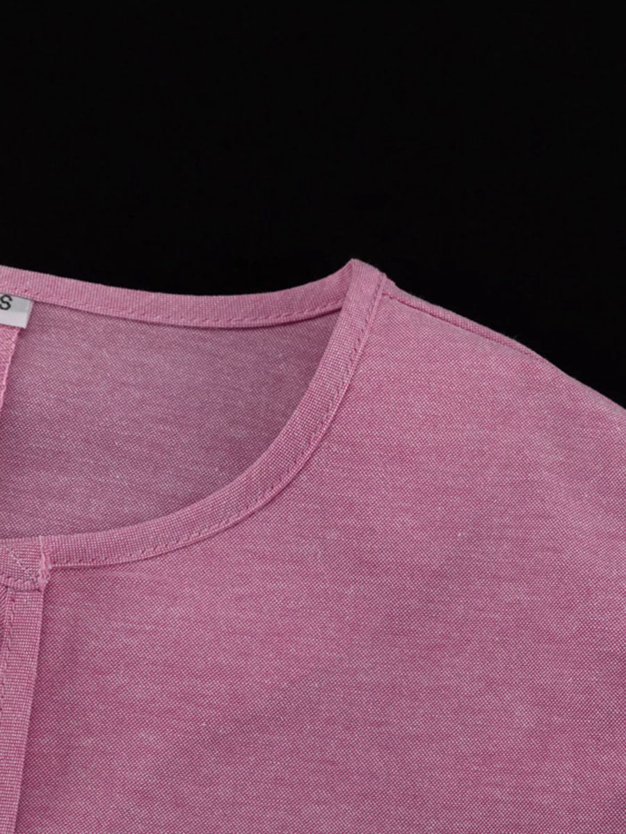 Pink cotton blend henley shirt with a rounded neckline and short sleeves.
