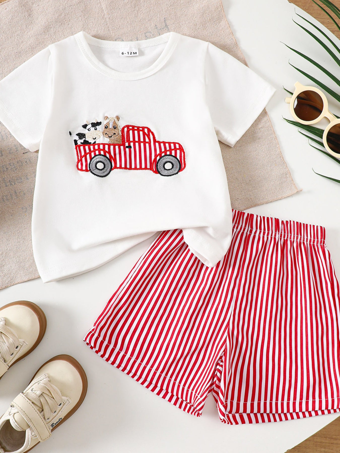 White baby tee with embroidered tractor, cow, and horse, paired with red striped shorts.