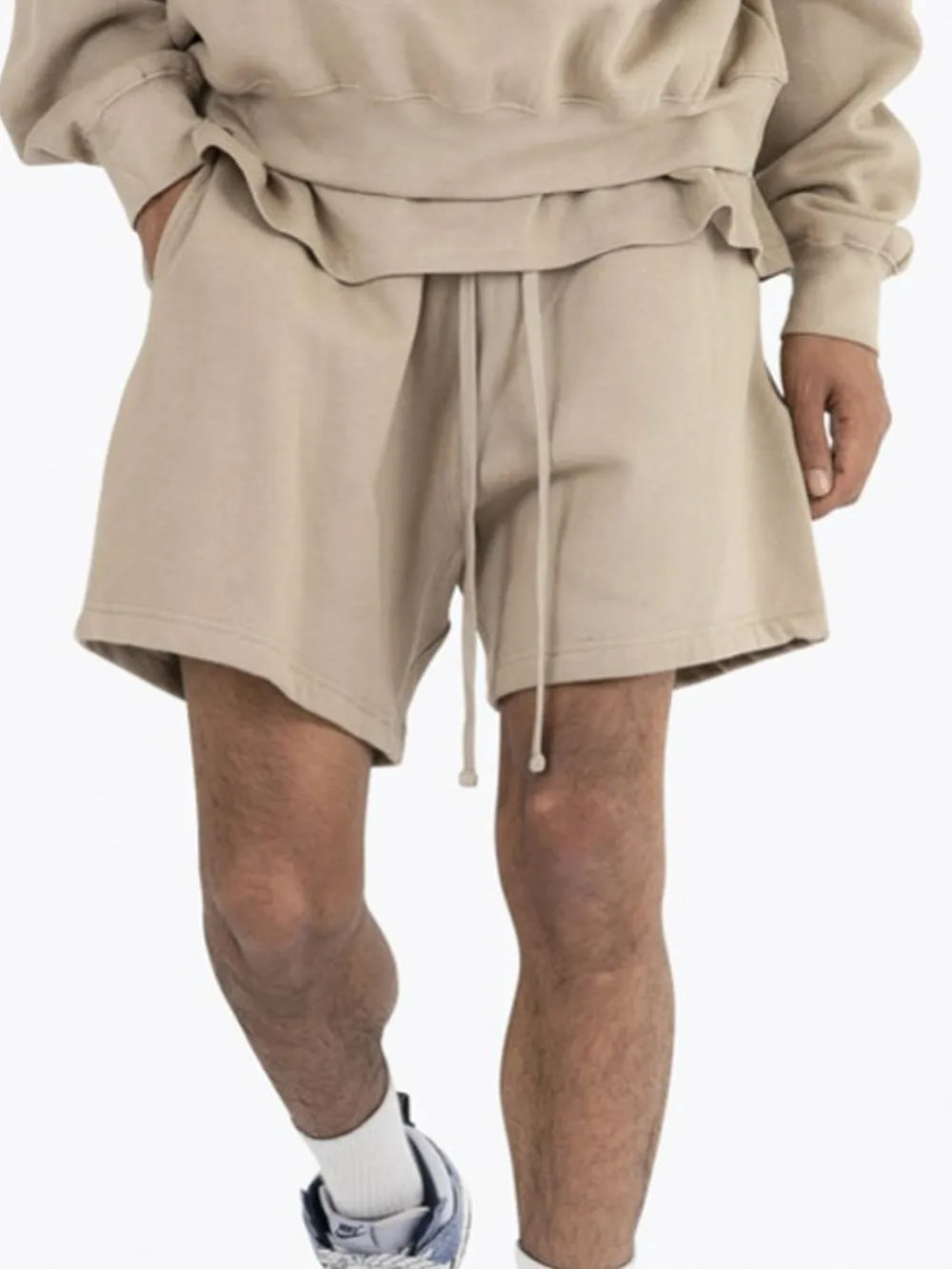 Relaxed fit beige cotton jersey jogger shorts with drawstring waist and side pockets.