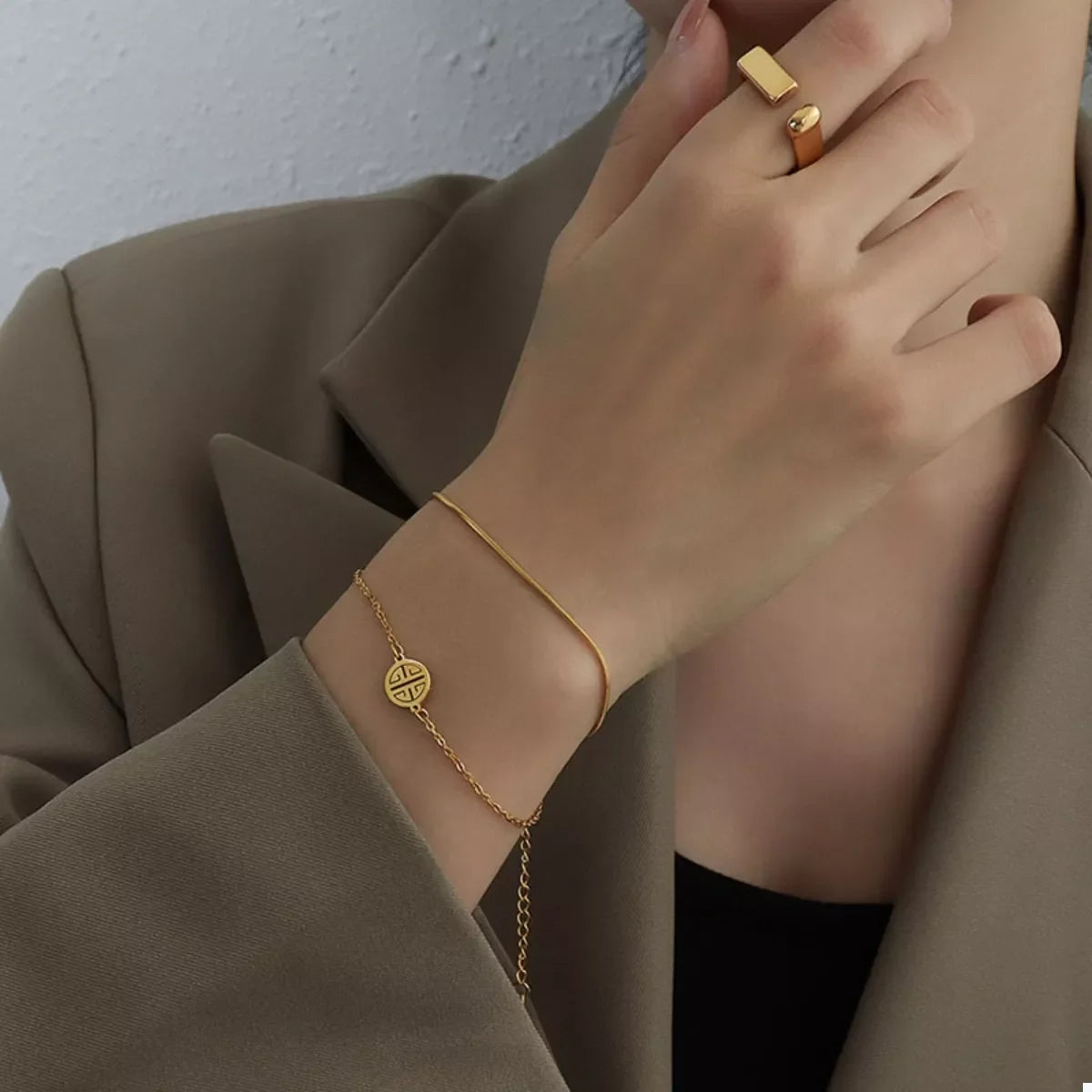 Gold double layered titanium steel bracelet with circular charm and adjustable chain