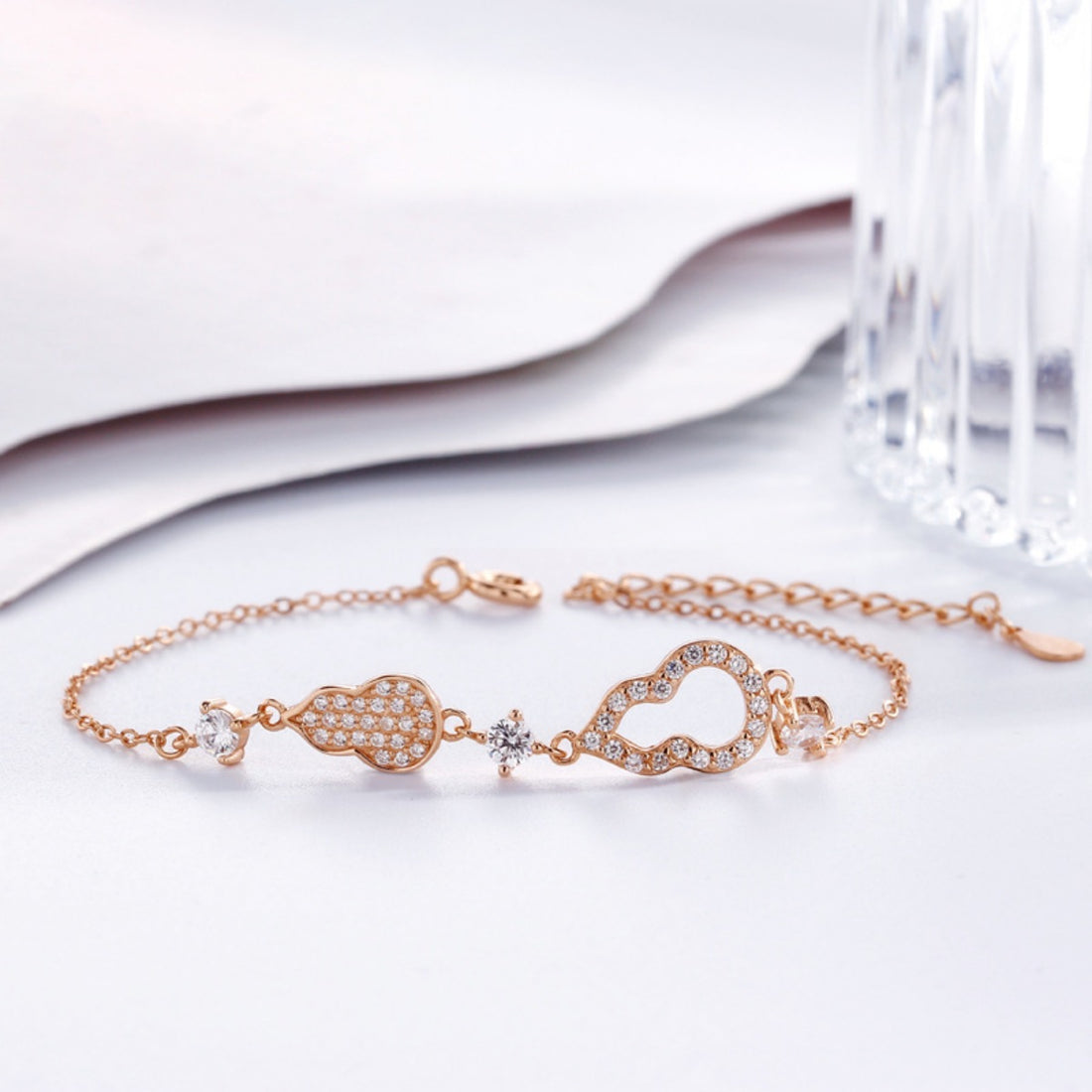Rose gold bracelet with gourd charms and cubic zirconia accents, adjustable chain.