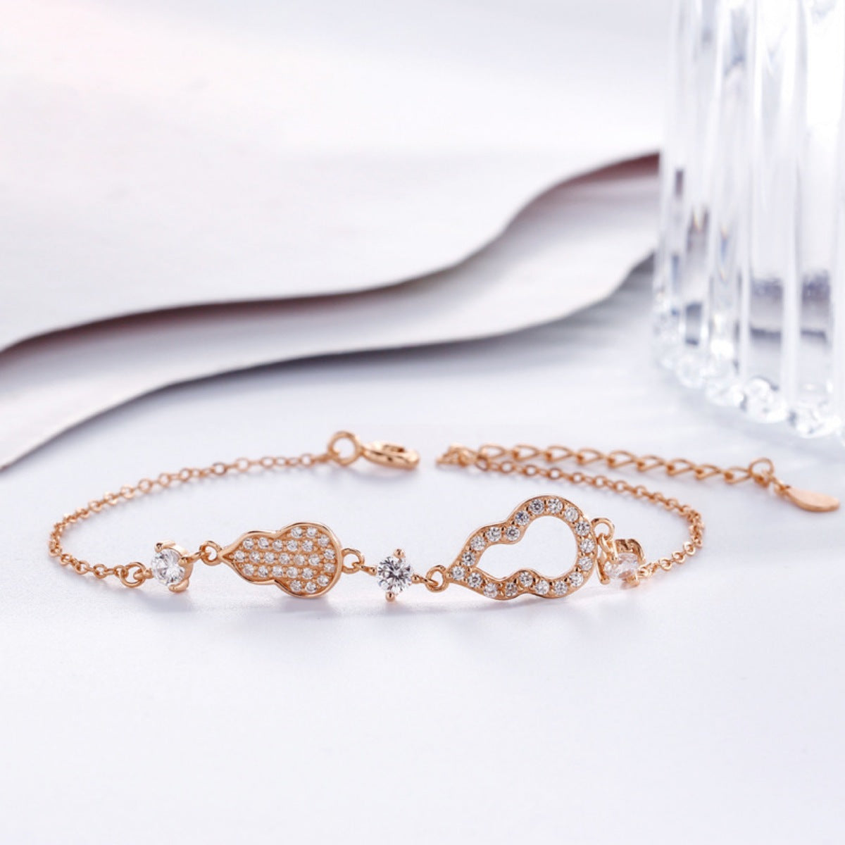 Rose gold bracelet with gourd charms and cubic zirconia accents, adjustable chain.