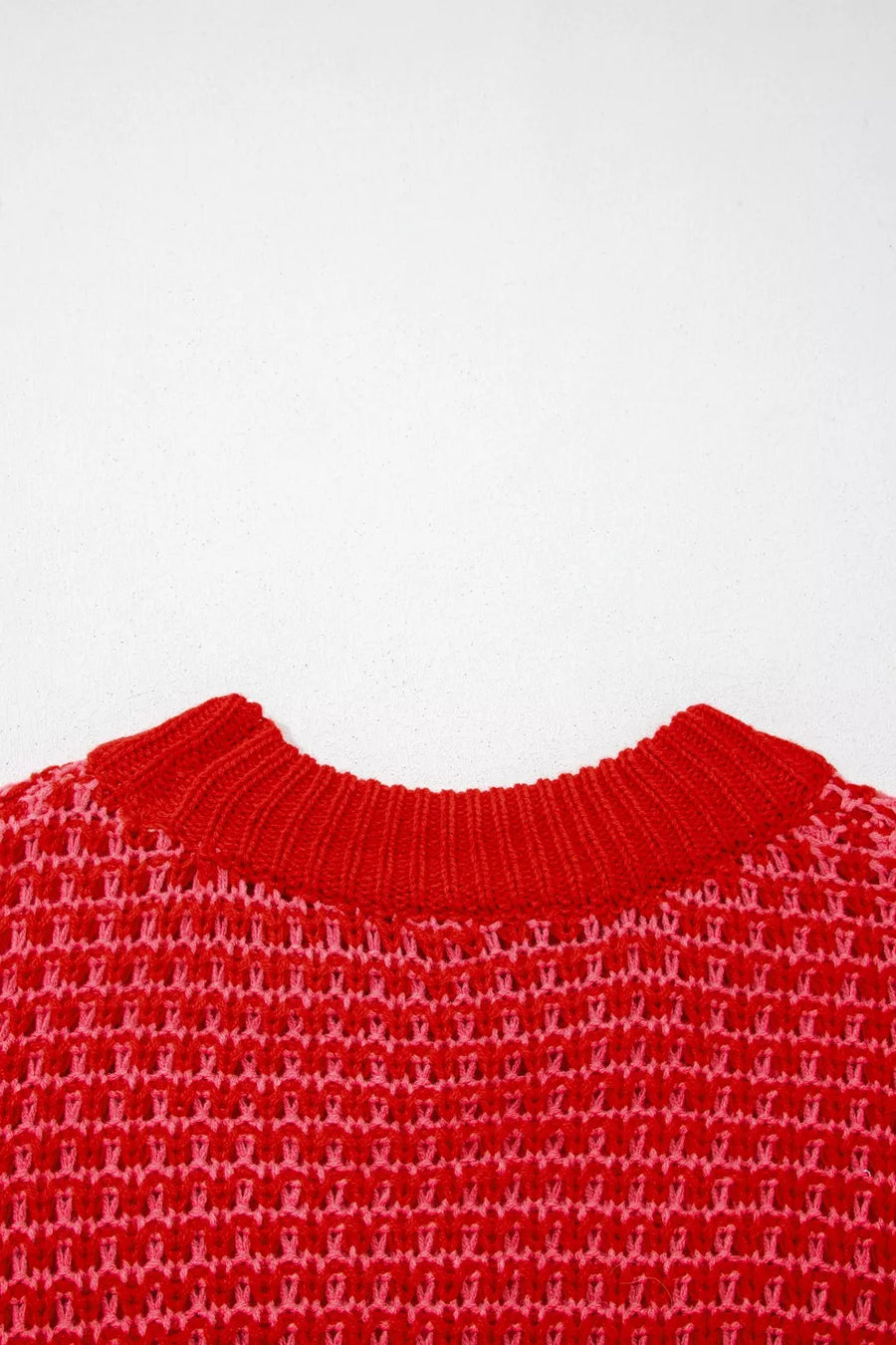 Red and pink acrylic knit sweater with crew neck and wavy crochet detail.