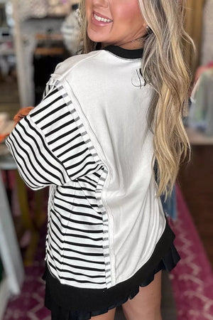 black sweatshirt featuring exposed seam and color-block