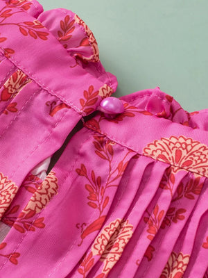 Pink floral print blouse with ruffled neckline and button detail.