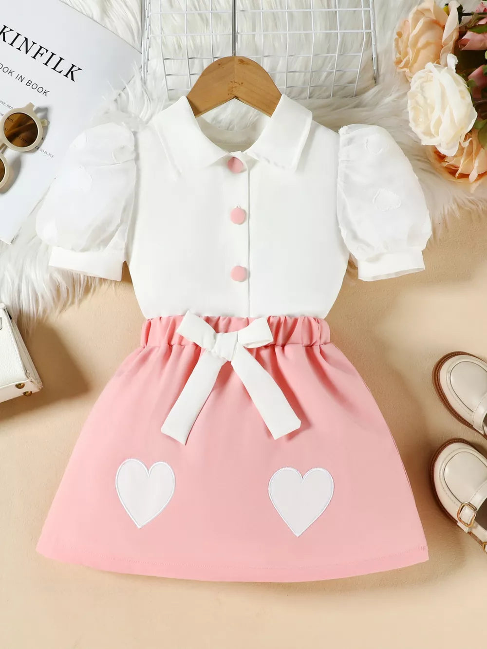 Pink baby girl outfit with white puff sleeve top and heart skirt with bow detail