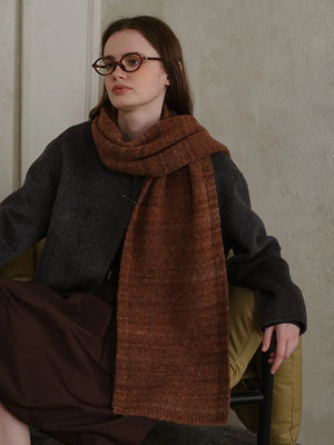 Textured mélange knit scarf in Terracotta, styled with a dark gray sweater.